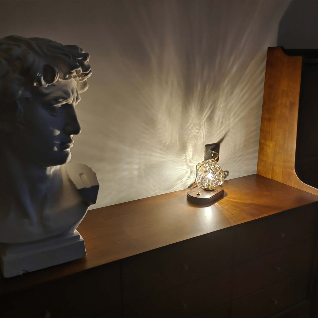 Szklana designerska lampa stołowa w kształcie bryły lodu jako element dekoracyjny