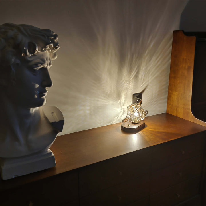 Szklana designerska lampa stołowa w kształcie bryły lodu jako element dekoracyjny