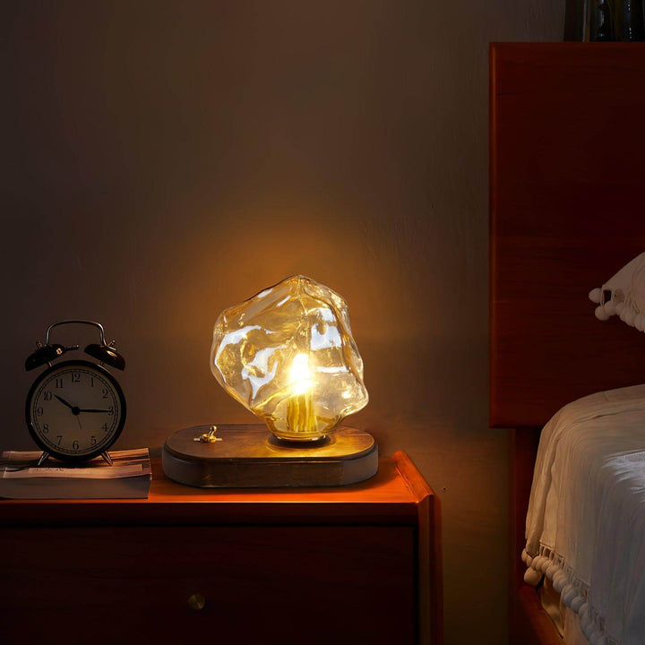 Szklana designerska lampa stołowa oświetlająca nowoczesne wnętrze