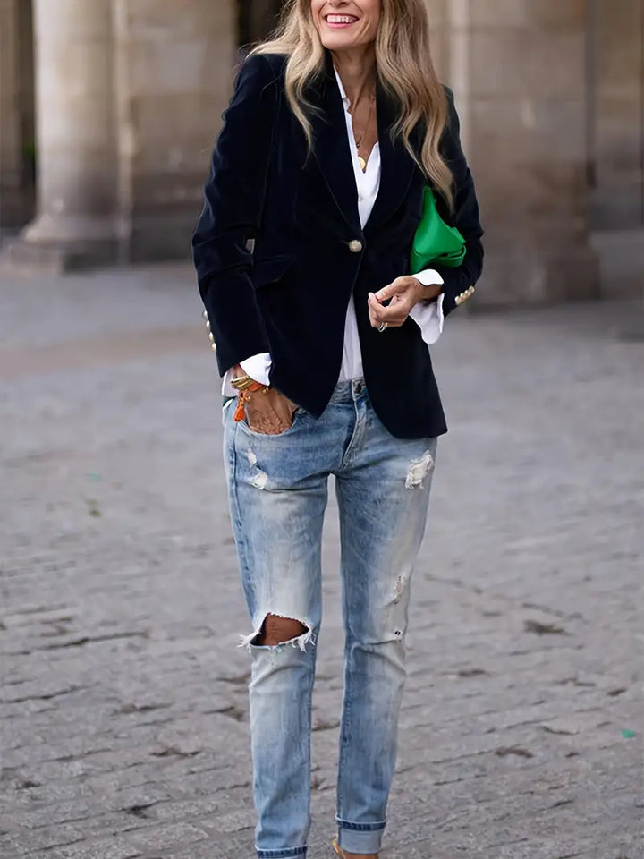 Elegancki aksamitny blazer damski, dopasowany krój i miękka tkanina, prezentowany na modelce, idealny do wyrafinowanych stylizacji.