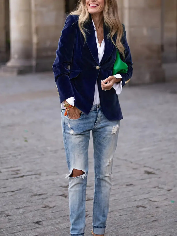 Elegancki aksamitny blazer damski, dopasowany krój i miękka tkanina, prezentowany na modelce, idealny do wyrafinowanych stylizacji.