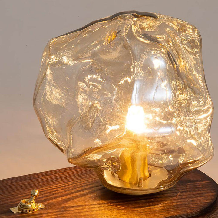 Szklana designerska lampa stołowa w kształcie bryły lodu z widokiem na podstawę