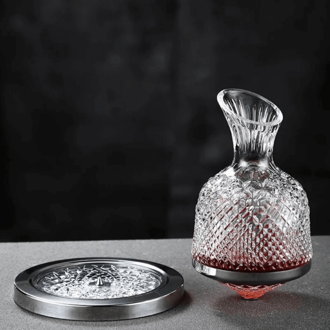 Obrotowa kryształowa karafka do wina, elegancki i nowoczesny design, srebrne wykończenie, na białym tle.