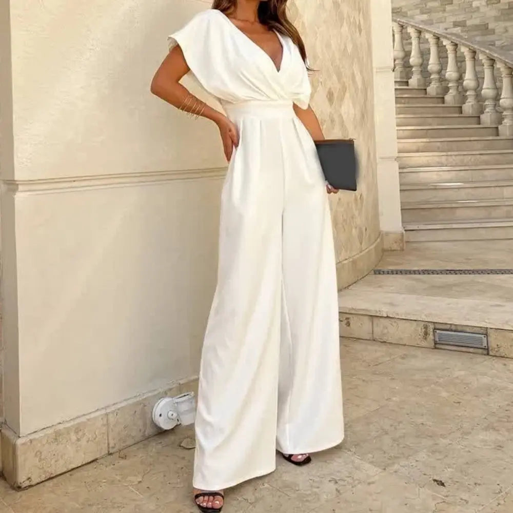 Elegancki kombinezon z szerokimi nogawkami, płynnym krojem i strukturalnymi rękawami, idealny na wieczorne wyjścia lub profesjonalne wydarzenia.