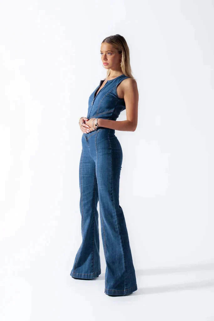 Nowoczesny damski kombinezon jeansowy w niebieskim kolorze, dopasowany krój z otwartymi plecami w kształcie serca, elegancki i wygodny dla odważnego stylu.
