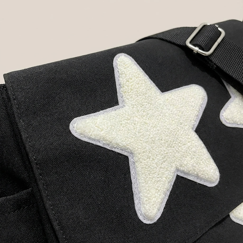 Pojemna torba messenger unisex Stellaro z czarnego poliestru, wzór gwiazdy, na ramię. Wodoodporna, idealna w podróż.