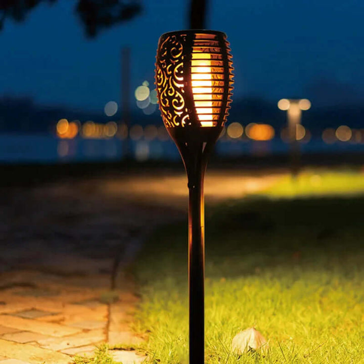 Zewnętrzna lampa solarna pochodnia na tle roślinności