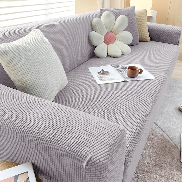 Housse de canapé extensible beige avec motif élégant et design antidérapant, disponible en plusieurs tailles pour salons mode