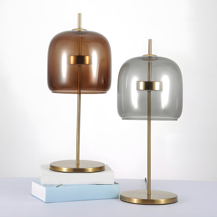 Lampa stołowa z przydymionego szkła, nowoczesny design, miękkie światło, idealna do wystroju wnętrz, ciepła atmosfera.