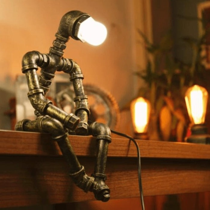 Lampa-robot z żelaza o regulowanym oświetleniu retro, ruchomymi ramionami i głową, wykończenie w kolorze mosiądzu, styl industrialny.