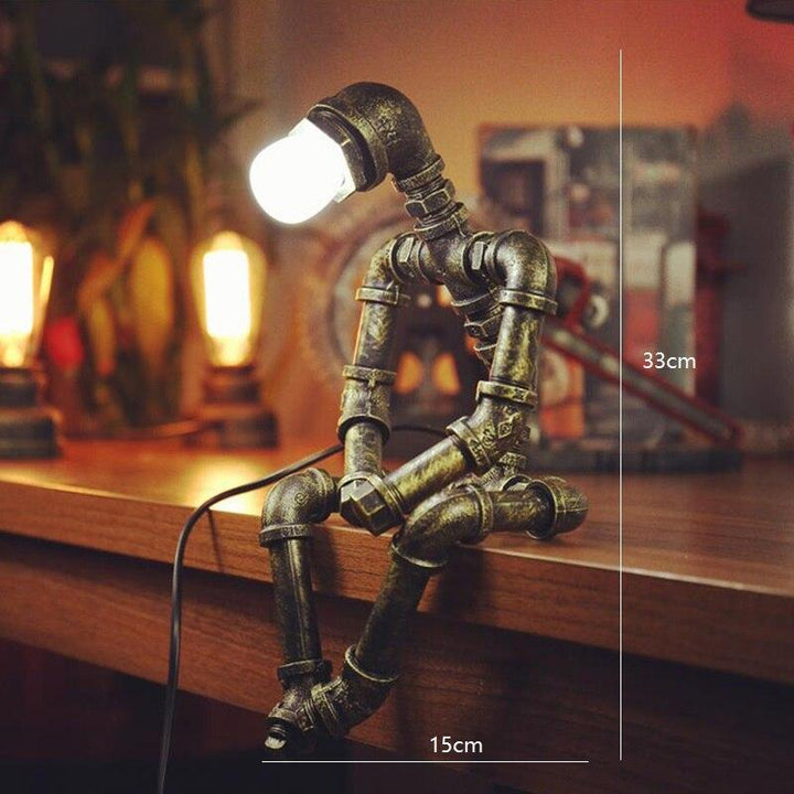 Lampa-robot z żelaza o regulowanym oświetleniu retro, ruchomymi ramionami i głową, wykończenie w kolorze mosiądzu, styl industrialny.
