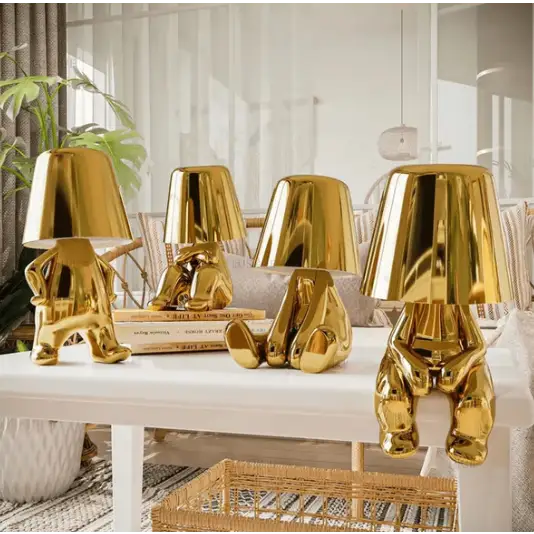 Złota lampa LED bezprzewodowa z rzeźbiarskim designem, tworząca ciepłą i przytulną atmosferę.