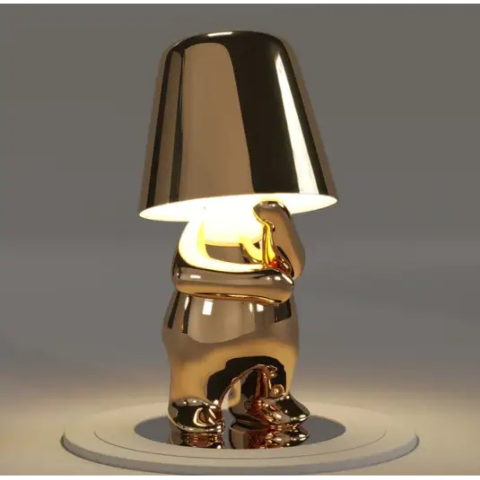 Lampa LED w kolorze złotym, bezprzewodowa, z detalami rzeźbiarskimi, dla nastrojowego oświetlenia.