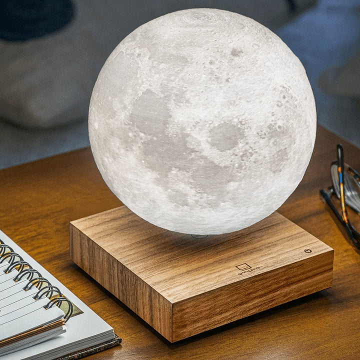 Lewitująca lampa księżycowa unosząca się w powietrzu, realistyczne kratery, na eleganckiej drewnianej podstawie, mistyczne oświetlenie wnętrza