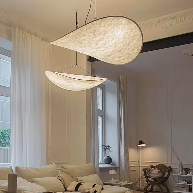 Designerski jedwabny abażur wiszący, o płynnych i eleganckich kształtach, tworzący miękkie światło dla szykownego i kojącego wnętrza.
