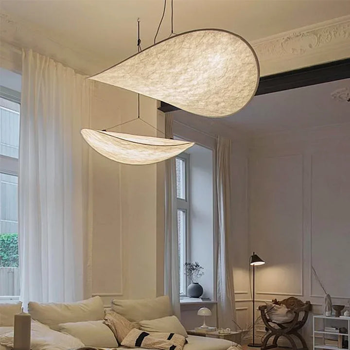 Designerski jedwabny abażur wiszący, o płynnych i eleganckich kształtach, tworzący miękkie światło dla szykownego i kojącego wnętrza.