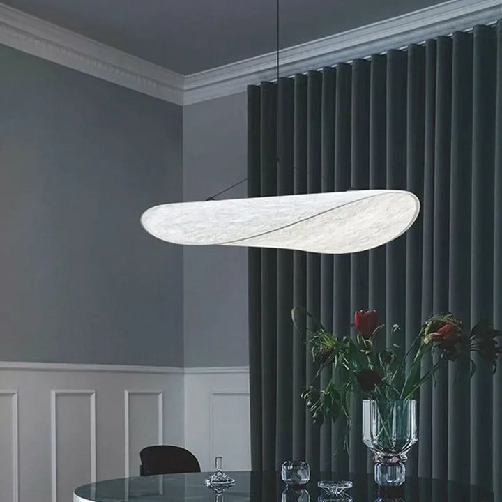 Designerski jedwabny abażur wiszący, o płynnych i eleganckich kształtach, tworzący miękkie światło dla szykownego i kojącego wnętrza.