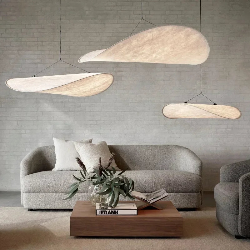Designerski jedwabny abażur wiszący, o płynnych i eleganckich kształtach, tworzący miękkie światło dla szykownego i kojącego wnętrza.