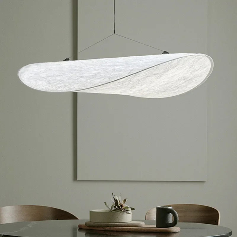 Designerski jedwabny abażur wiszący, o płynnych i eleganckich kształtach, tworzący miękkie światło dla szykownego i kojącego wnętrza.