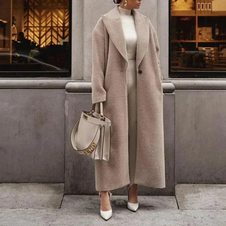 Detale długiego eleganckiego płaszcza zimowego, ukazujące wysoką jakość wykonania i modny design.