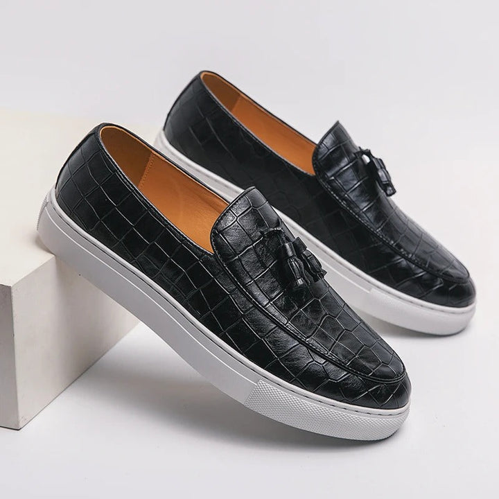 Brązowe męskie loafersy skórzane, eleganckie i wygodne, na białym tle.