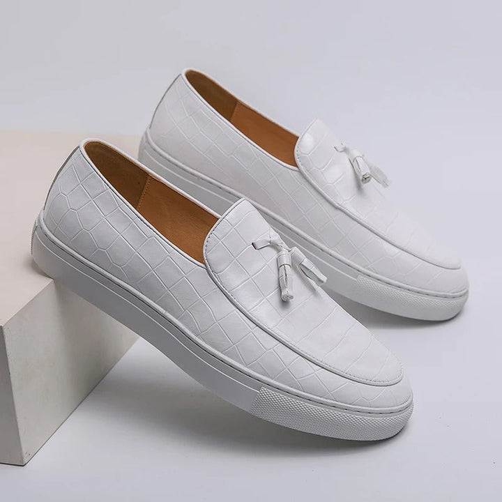 Brązowe męskie loafersy skórzane, eleganckie i wygodne, na białym tle.