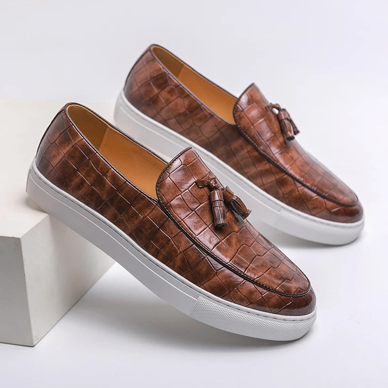 Brązowe męskie loafersy skórzane, eleganckie i wygodne, na białym tle.
