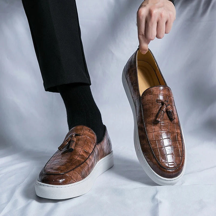 Brązowe męskie loafersy skórzane, eleganckie i wygodne, na białym tle.