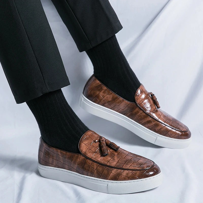 Brązowe męskie loafersy skórzane, eleganckie i wygodne, na białym tle.