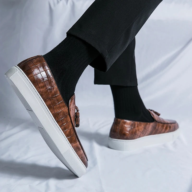 Brązowe męskie loafersy skórzane, eleganckie i wygodne, na białym tle.