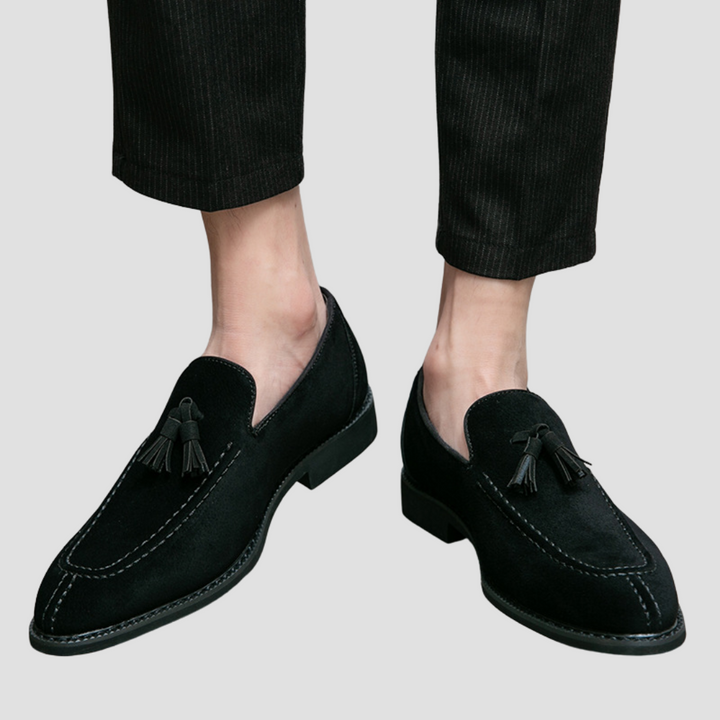 Męskie mokasyny z zamszu, widok z boku, w kolorze ciemnego brązu z eleganckimi chwostami, gumowa podeszwa, wyrafinowany styl.