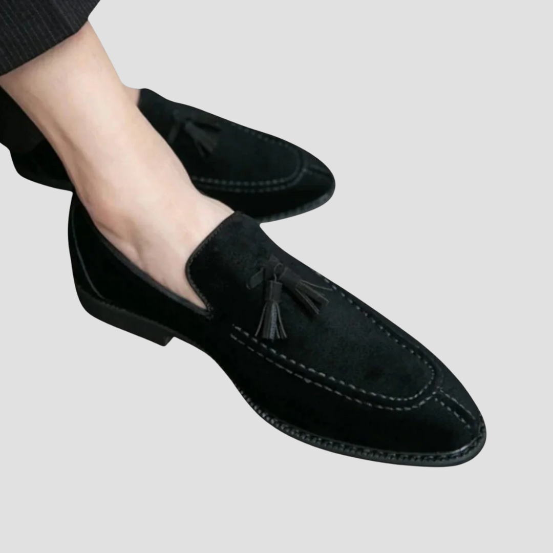 Męskie mokasyny z zamszu, widok z boku, w kolorze ciemnego brązu z eleganckimi chwostami, gumowa podeszwa, wyrafinowany styl.