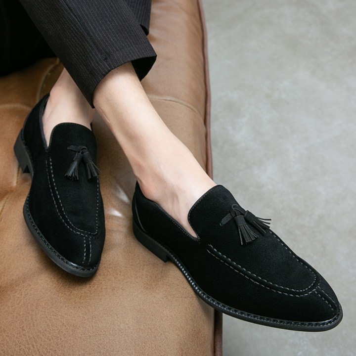 Męskie mokasyny z zamszu, widok z góry, w kolorze ciemnego brązu z eleganckimi chwostami, gumowa podeszwa, wyrafinowany styl.