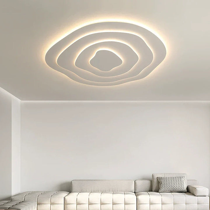 Nowoczesna lampa sufitowa LED o asymetrycznym designie, kremowym wykończeniu, artystycznych krzywiznach, modulowanym świetle oraz wykonana z metalu i akrylu.