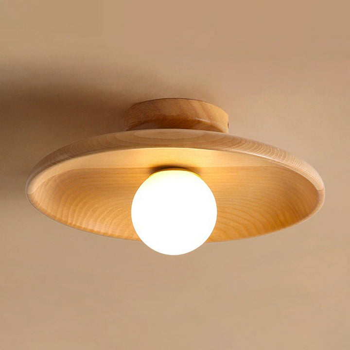 Nowoczesna płaska lampa sufitowa z brązowego drewna o eleganckim designie, delikatnie i równomiernie rozświetlająca wnętrze.