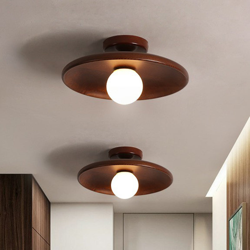 Nowoczesna płaska lampa sufitowa z brązowego drewna o eleganckim designie, delikatnie i równomiernie rozświetlająca wnętrze.