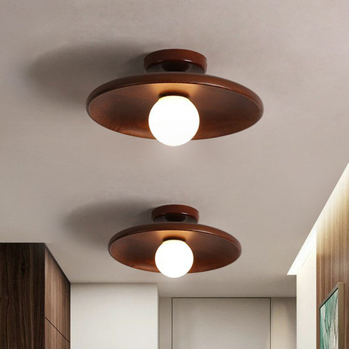 Nowoczesna płaska lampa sufitowa z brązowego drewna o eleganckim designie, delikatnie i równomiernie rozświetlająca wnętrze.