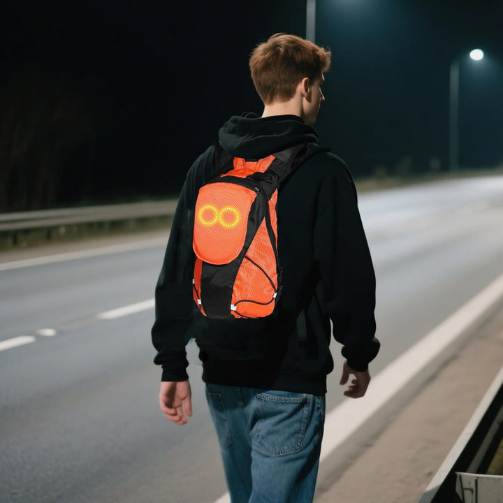 Plecak motocyklowy LED na plecach kierowcy, świecący w nocy, zwiększający bezpieczeństwo na drodze.
