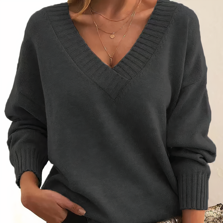 Damski sweter z dekoltem V, elegancki i miękki, na beżowym tle, idealny do codziennej elegancji i lekkiego ciepła.