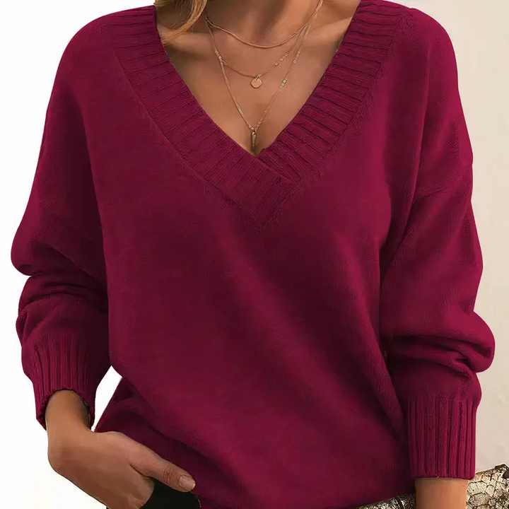 Damski sweter z dekoltem V, elegancki i miękki, na beżowym tle, idealny do codziennej elegancji i lekkiego ciepła.