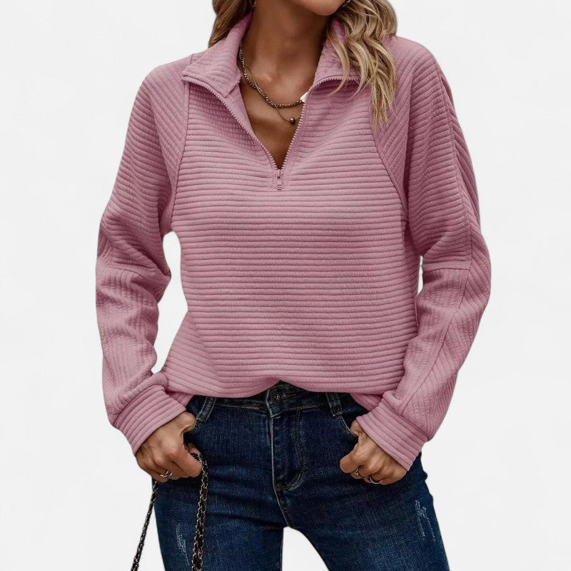 Ciepły sweter damski z prążkowanej dzianiny, zapinany na zamek pod szyją. Idealny do stworzenia luźnej, ale eleganckiej stylizacji. Nowoczesna faktura i modny fason.