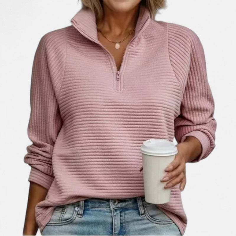 Stylowy sweter damski z prążkowanego materiału, z wysokim kołnierzem zapinanym na suwak. Zapewnia komfort i swobodę ruchu, a jednocześnie podkreśla elegancję. Szczegóły splotu.