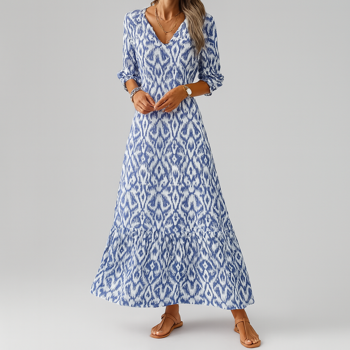 Długa sukienka damska boho z nadrukiem ikat, styl luźny, dekolt V, rękawy 3/4, płynna sylwetka, elegancka letnia.
