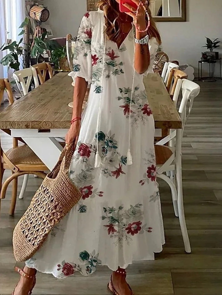 Beżowa sukienka maxi boho z etnicznymi wzorami, luźny krój, detale do wiązania, idealna na lato i elegancka.