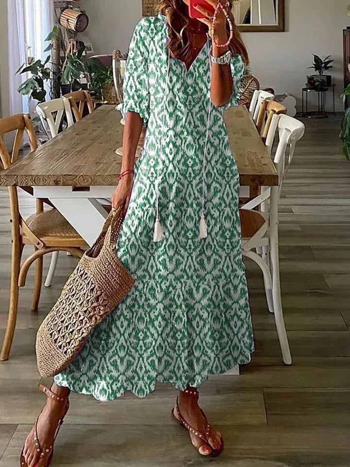 Beżowa sukienka maxi boho z etnicznymi wzorami, luźny krój, detale do wiązania, idealna na lato i elegancka.