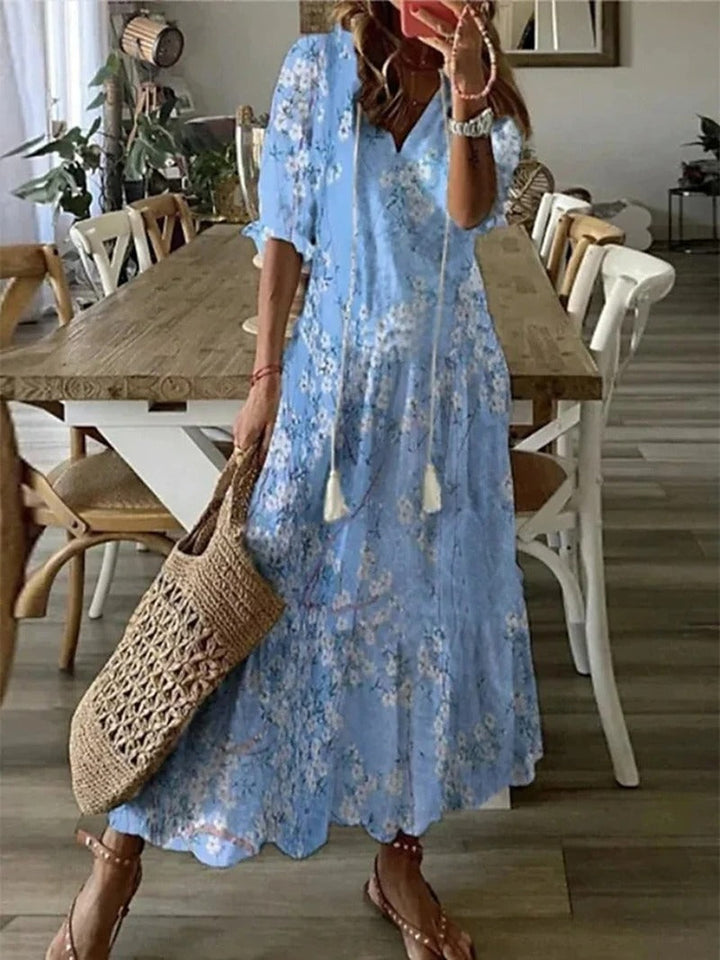 Beżowa sukienka maxi boho z etnicznymi wzorami, luźny krój, detale do wiązania, idealna na lato i elegancka.