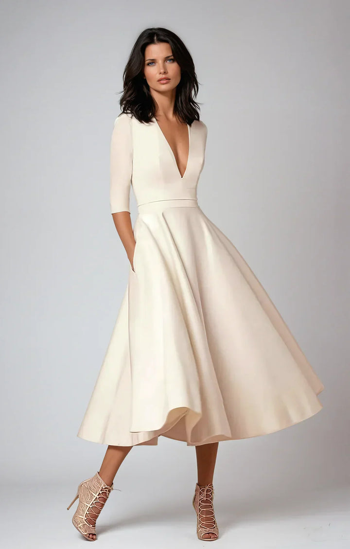 Modelka w eleganckiej sukience midi z fakturowanym materiałem i głębokim dekoltem w serek.