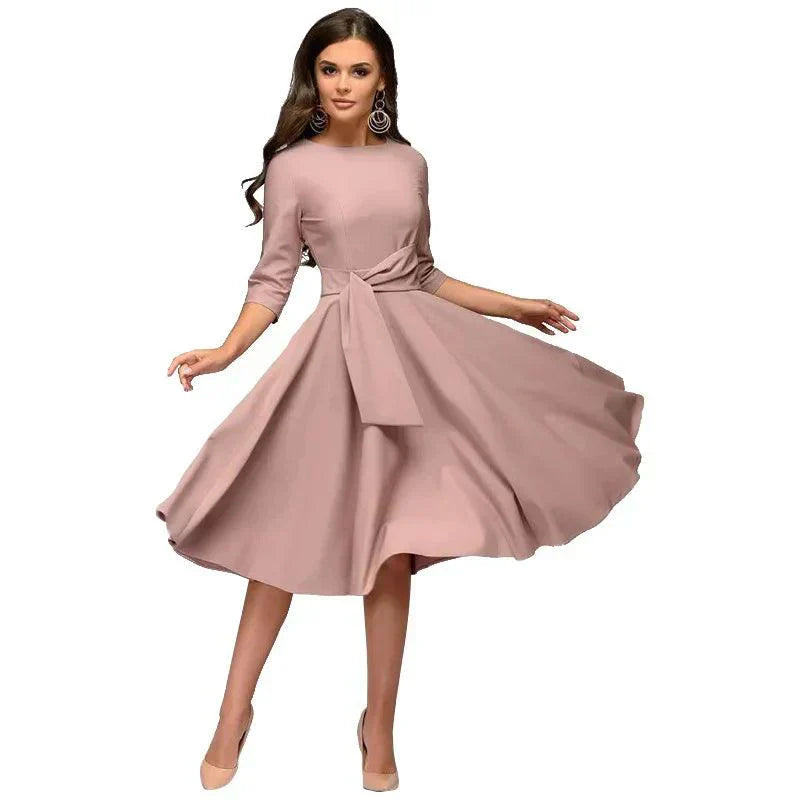 Elegancka sukienka midi z detalami wiązania, lekki i zwiewny materiał, odpowiednia na formalne lub codzienne wyjścia.