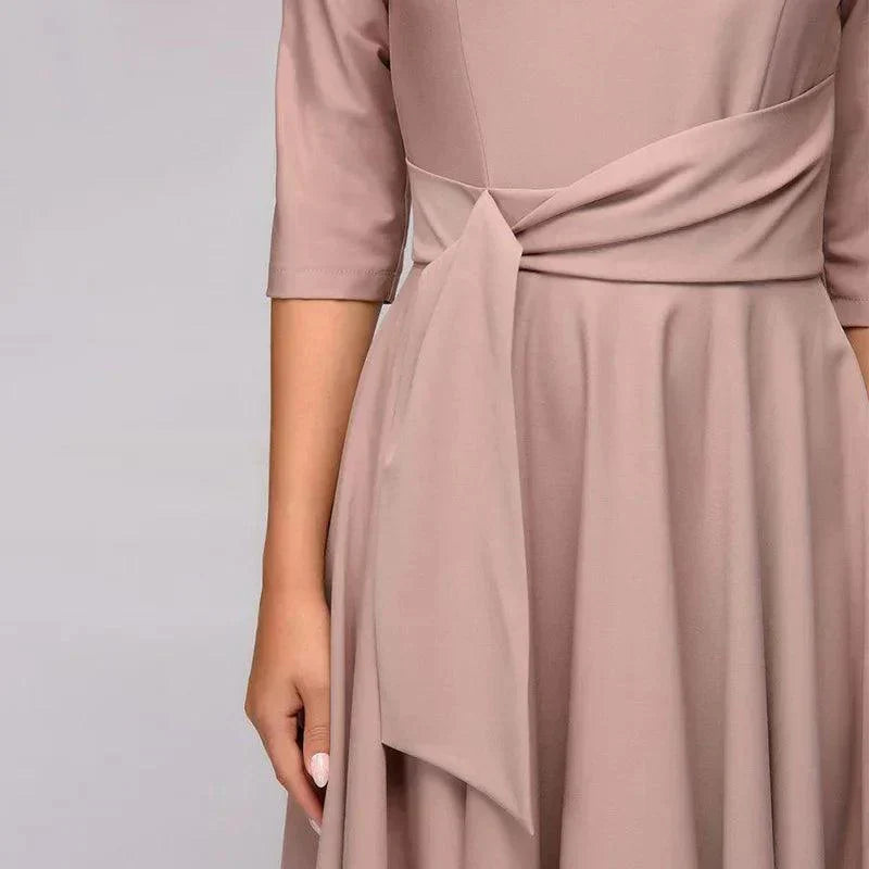 Elegancka sukienka midi z detalami wiązania, lekki i zwiewny materiał, odpowiednia na formalne lub codzienne wyjścia.