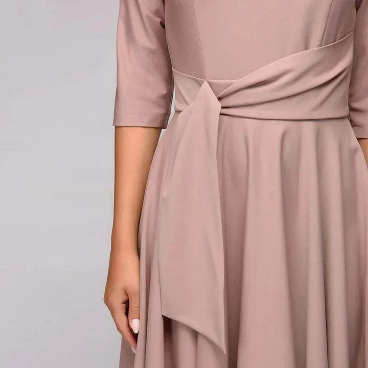 Elegancka sukienka midi z detalami wiązania, lekki i zwiewny materiał, odpowiednia na formalne lub codzienne wyjścia.